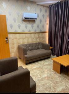 a living room with a couch and a tv at Goldstep Hotel Asaba in Asaba +16 photos