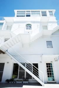 a white building with a white staircase at We Stay Inn in Eluan