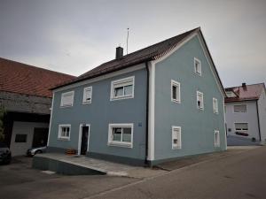 a blue house with white windows on a street at Zum oid'n Leidlhof in Berching
