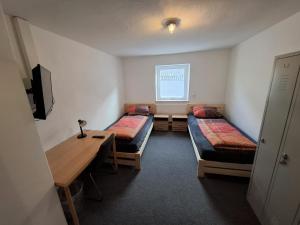a room with three beds and a table and a window at Zum oid'n Leidlhof in Berching