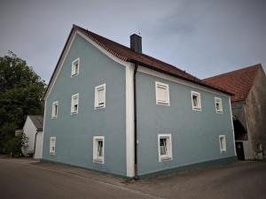 a blue house with white windows on a street at Zum oid'n Leidlhof in Berching
