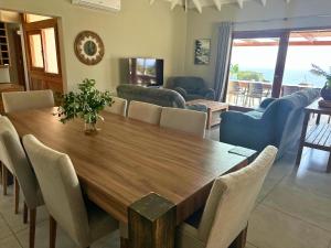a dining room with a wooden table and chairs at Makana 3A in Ponta Mamoli +15 photos