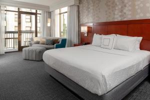 a hotel room with a large bed and a chair at Courtyard Memphis Downtown in Memphis +19 photos