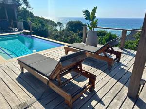 a deck with a chair and a swimming pool at Makana 3A in Ponta Mamoli