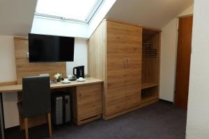 a room with a desk with a computer and a television at Hotel Allee 25 in Stuttgart