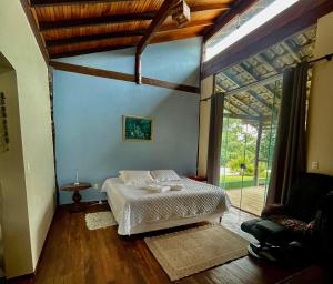 a bedroom with a bed and a large window at Sitio Tashi Delek in Cavalcante