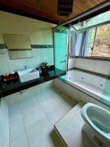 a bathroom with a sink and a tub and a toilet at Sitio Tashi Delek in Cavalcante +53 photos