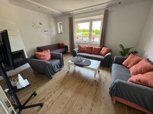 a living room with two couches and a table at Haus Teveren in Geilenkirchen