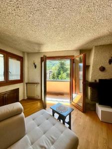 a living room with a couch and a table at Appartamento Lisander in Ponte di Legno