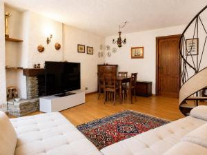a living room with a television and a table at Appartamento Lisander in Ponte di Legno +8 photos