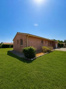 a brick house with a grass yard in front of it at Maison Mirepoix 100m2 in Mirepoix