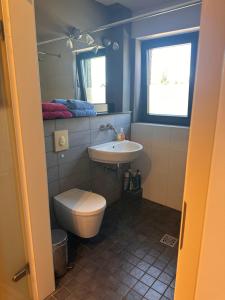 a bathroom with a toilet and a sink at Oase für Reisende & Geschäftsleute in Meerbusch +8 photos