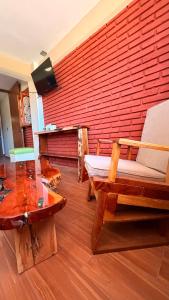 a living room with a red brick wall and a chair at Hotel Spa Chignahuapan Mágico in Chignahuapan +29 photos