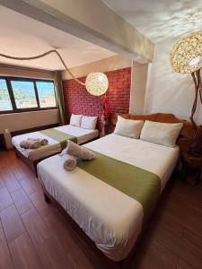 a bedroom with two beds and a chandelier at Hotel Spa Chignahuapan Mágico in Chignahuapan