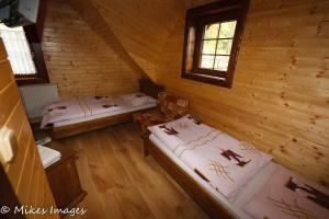 a room with two beds in a log cabin at Chata u sváka Jana in Terchová