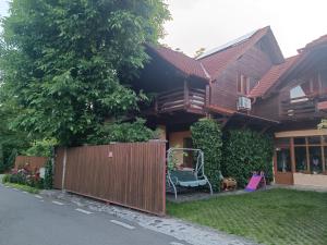 a house with a wooden fence and a playground at Pasager House in Sovata
