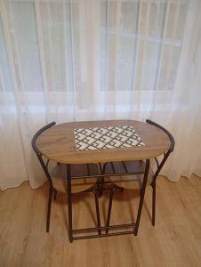 a wooden table and a chair sitting in front of a window at Stan na dan ,, Vidovdan ,, in Nevesinje