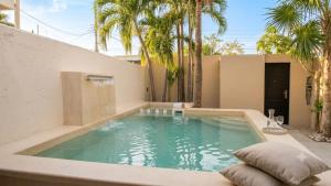 a swimming pool in the backyard of a house with palm trees at Residencia COCO 28 con Piscina Downtown Cancun in Cancún