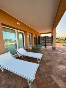 a patio with two tables and chairs on a building at Plemmirio Marèa in Plemmirio