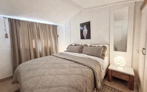 a white bedroom with a large bed and a window at Villa Stone House Poplat in Vela Luka