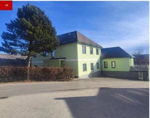 a yellow and green house with a tree in front of it at Max and Moritz Top 9 in Liebenau