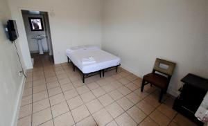 a small room with a bed and a chair at Sunset Motel in Las Vegas