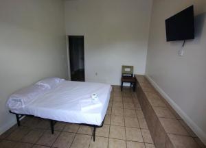 a bedroom with a bed and a flat screen tv at Sunset Motel in Las Vegas +4 photos