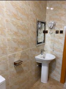 a bathroom with a sink and a mirror at Goldstep Hotel Asaba in Asaba