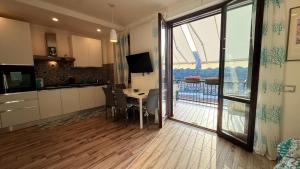 a kitchen and dining room with a table and a balcony at argentario home in Porto Santo Stefano