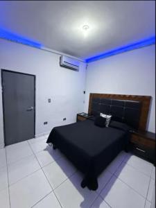 a bedroom with a black bed and a blue light at Feng tower in Culiacán