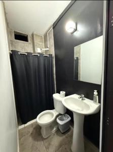 a bathroom with a white toilet and a sink at Feng tower in Culiacán +3 photos