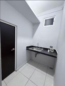 a bathroom with a sink and a black door at Feng tower in Culiacán