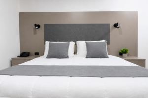 a bedroom with a large white bed with two pillows at NOVA Apartahotel in Medellín +36 photos
