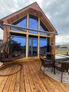 a wooden deck with a house with a table at Barnhouse in Bosteri