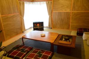 a small living room with a table and a couch at Sai no Tsuno Guest House in Ueda