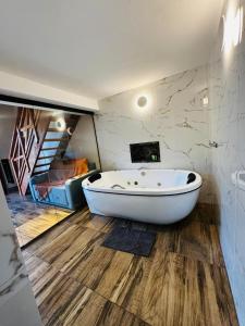 a large bath tub in a room with a staircase at Chalé Recanto Figueira in Camanducaia