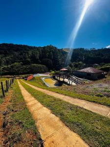 a dirt road with a beam of light in the sky at Chalé Recanto Figueira in Camanducaia