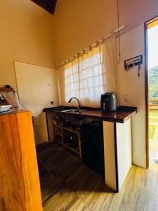 a kitchen with a counter and a sink in a room at Chalé Recanto Figueira in Camanducaia