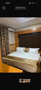 a bedroom with a large bed with a headboard at Goldstep Hotel Asaba in Asaba