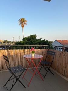 a red table and two chairs on a patio at Casa DeA in Giardini Naxos