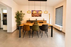 a dining room with a wooden table and chairs at Escale Tout Confort Maison entière Parking gratuit Proche Aéroport Charleroi in Charleroi +13 photos