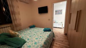 a bedroom with a bed and a flat screen tv at argentario home in Porto Santo Stefano