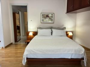 a bedroom with a large white bed with two lamps at Dream Home Thiva in Thiva
