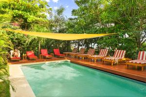 a swimming pool with chairs and a hammock over it at Hotel Café Con Leche in Playa Santana
