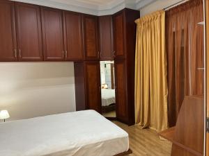 a bedroom with a bed and wooden cabinets at Dream Home Thiva in Thiva