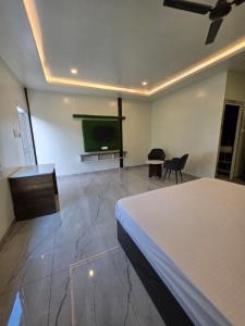 a bedroom with a bed and a flat screen tv at Ganga Bliss Riverside in Haridwār