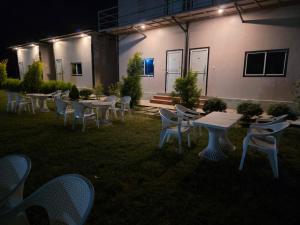 a group of tables and chairs in a yard at night at Ganga Bliss Riverside in Haridwār