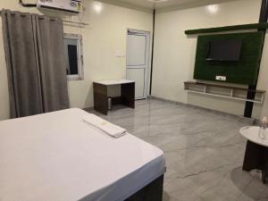 a hospital room with a bed and a flat screen tv at Ganga Bliss Riverside in Haridwār