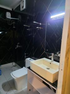 a bathroom with a sink and a toilet at Ganga Bliss Riverside in Haridwār +4 photos
