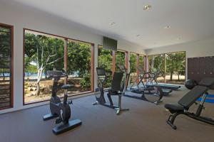 a gym with several treadmills and ellipticals and windows at Le Domaine Deva, Series by Marriott in Bourail